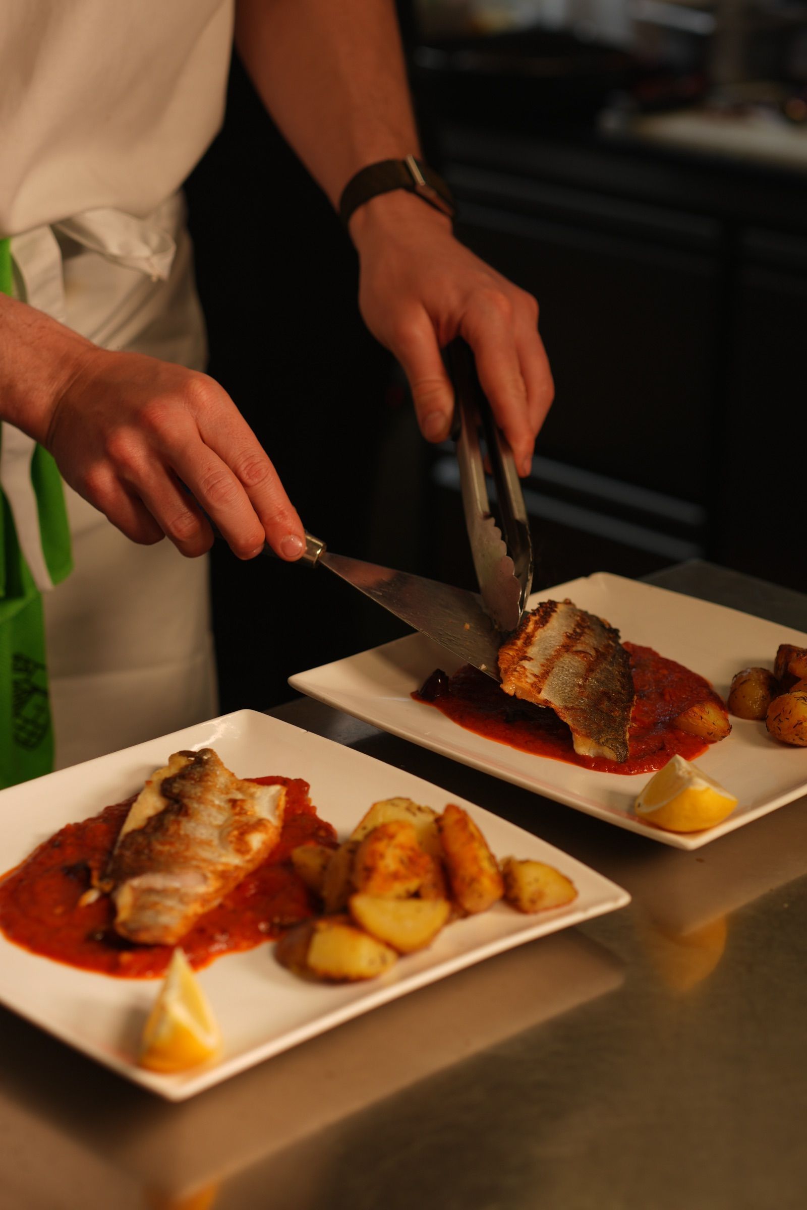 Branzino alla Puttanesca – tagesfrischer Fisch, in der Küche angerichtet