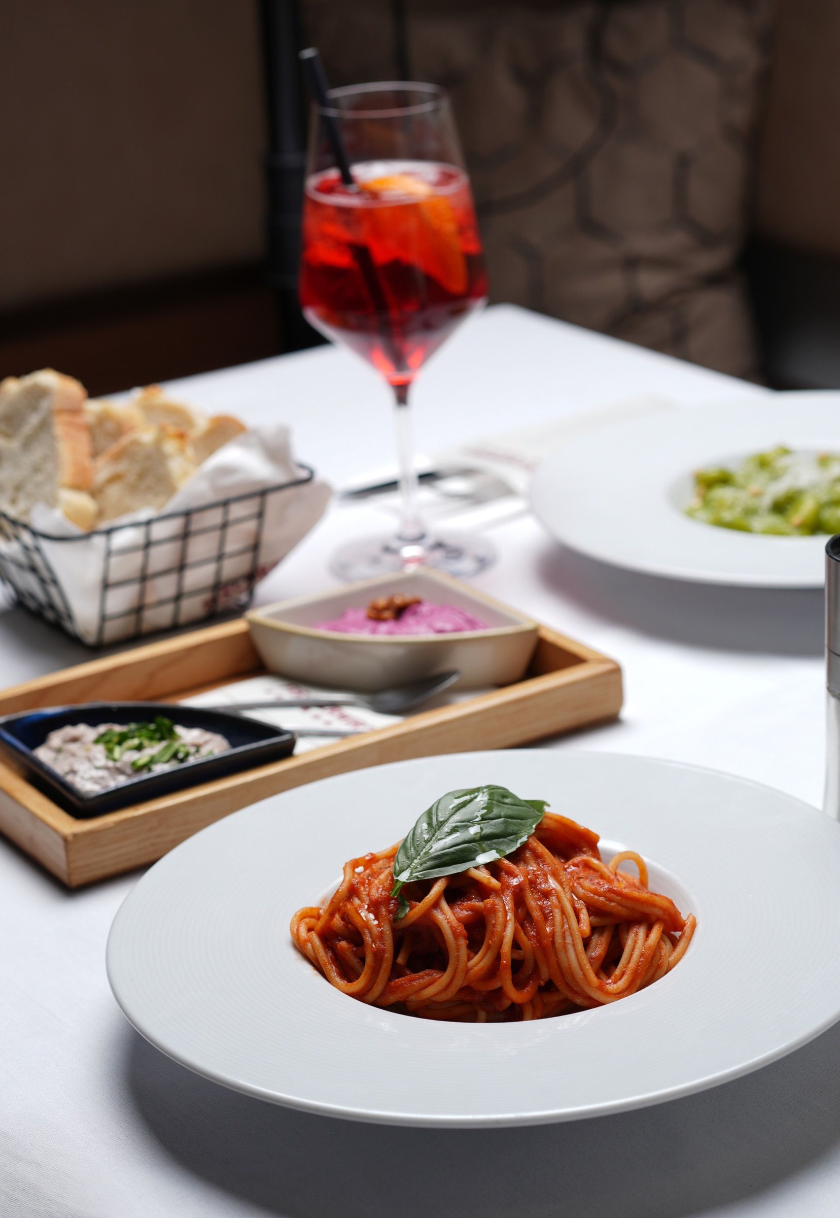 Gedeckter Tisch mit Spaghetti al Pomodoro und Spritz im Fischerwirt con amore